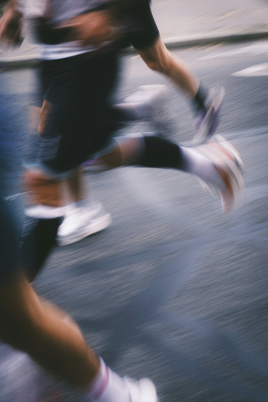 Pernas de corredores em movimento na rua